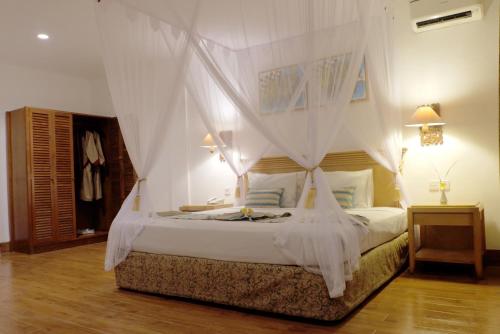 塞米亚克水明漾帕达迪索酒店的一间卧室配有一张带天蓬的白色床