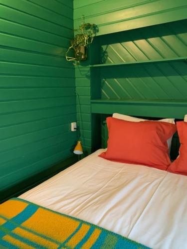西泰尔斯海灵阿尔提耶德瓦德住宿加早餐酒店的一间卧室设有绿色的墙壁和一张带红色枕头的床