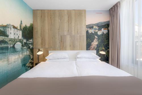 茨里克韦尼察Boutique Hotel Esplanade的卧室设有白色的床和大窗户