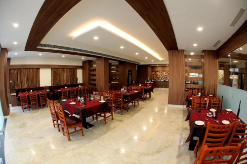 塞勒姆Rathna Residency的一间在房间内配有桌椅的餐厅
