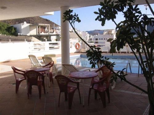 圣何塞维斯塔玛尔圣何塞公寓式酒店的游泳池旁带桌椅的天井