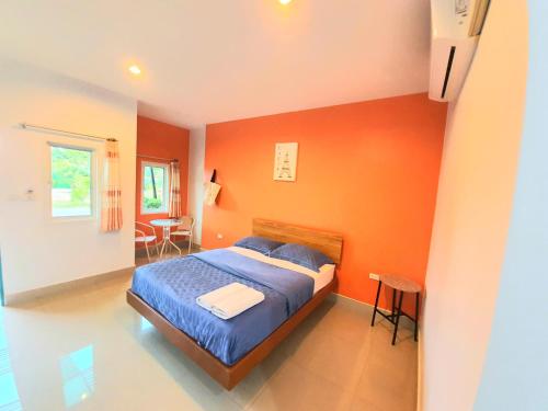 班昌月光度假酒店的一间卧室拥有橙色的墙壁,里面设有一张床