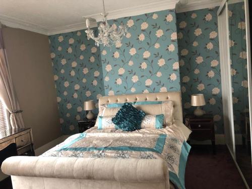 米德尔斯伯勒Southfield lodge的一间卧室配有一张蓝色花卉壁纸床