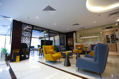 吉达Bait Aldiyafah Hotel Apartments的大堂设有黄色和蓝色的椅子和桌子
