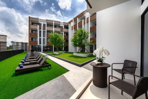 华欣iSanook Resort & Suites Hua Hin的公寓庭院设有绿色草坪和建筑