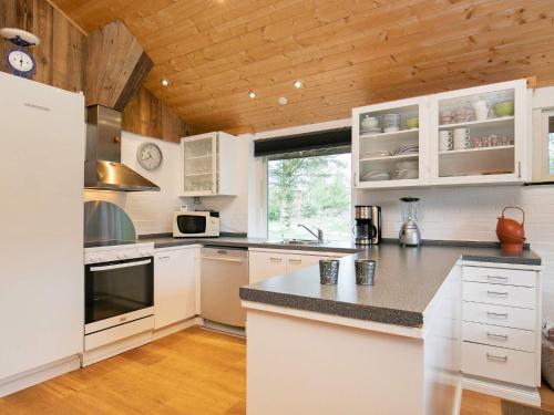 法贾德嘉德6 person holiday home in Ulfborg的一间厨房,配有白色家电和木制天花板
