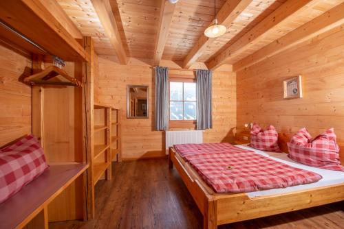 普鲁格恩Berghüttn Pruggern的小木屋内一间卧室,配有一张床