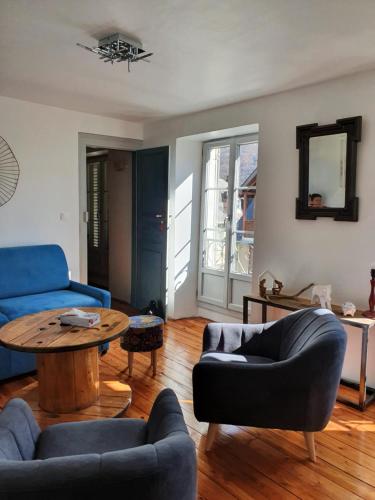 巴涅尔-德吕雄BEL APPARTEMENT LUCHON CENTRE WIFI - CLIMATISATION 6 COUCHAGES的客厅配有蓝色的沙发和桌子