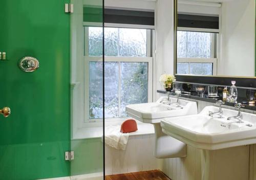 亚达尔The Dunraven, Adare的绿色和白色的浴室设有两个水槽和窗户