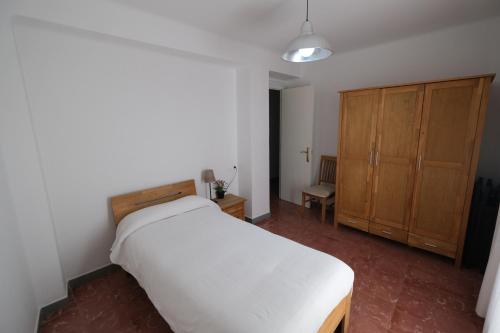 塔拉戈纳Apartament Tarracoliva的卧室配有白色的床和木制橱柜。