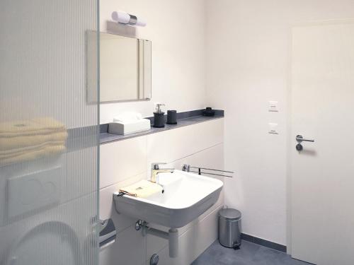 沙夫豪森Atrium Apartments的白色的浴室设有水槽和镜子