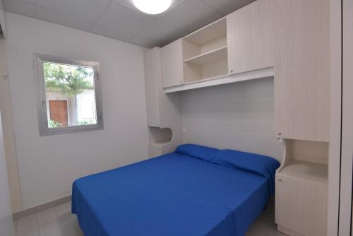 玛丽娜法尔梦思Camping Johnny的一间卧室设有蓝色的床和白色的墙壁