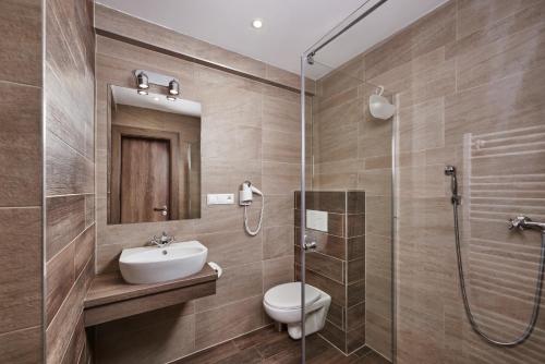 VernárHotel Studničky的浴室配有卫生间、盥洗盆和淋浴。