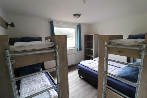 霍勒姆Sier aan Zee的客房设有三张双层床和一扇窗户。