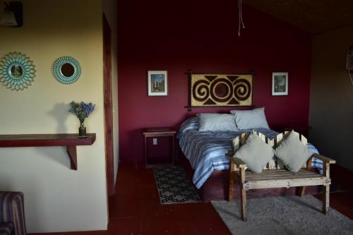 瓜达鲁佩镇Bajo el Sol del Valle的一间卧室配有一张床和长凳
