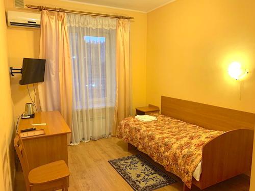 基辅Inn on Zhytomyrska的一间卧室配有一张床、一张书桌和一个窗户。