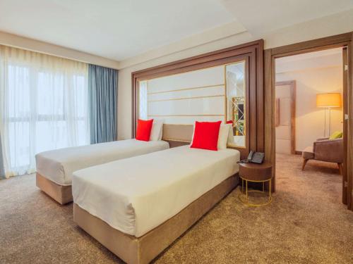 伊斯坦布尔伊斯坦布尔博蒙蒂宜必思尚品酒店的酒店客房 - 带两张带红色枕头的床