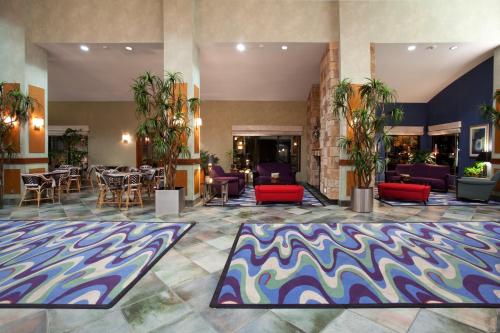罗克斯普林罗克斯普林假日旅馆的大堂配有桌椅和色彩缤纷的地毯。