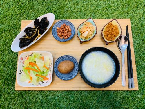 鱼池乡日月潭沅居民宿 YUAN JU BOUTIQUE Hotel的装有碗食物和盘子的木托盘