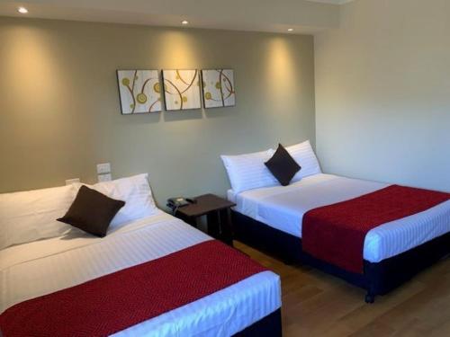 韦帕Weipa Motel Resort的酒店客房带两张床和电话