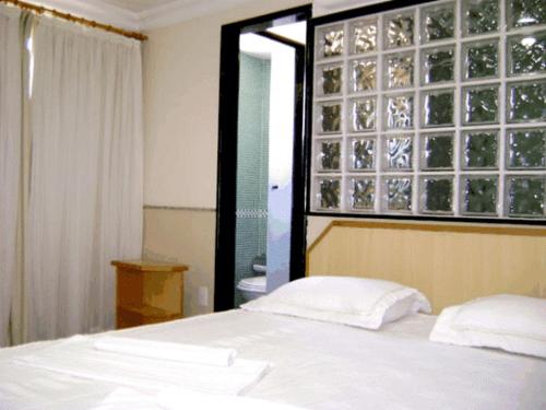 马卡埃罗莎马尔酒店的卧室配有白色的床和窗户。