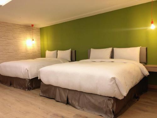 台南台南嘉园旅店的绿墙客房的两张床