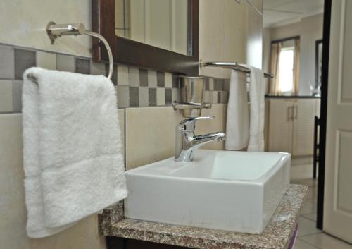 阿曼济姆托蒂Sunrise Beach Resort的浴室配有白色水槽和毛巾
