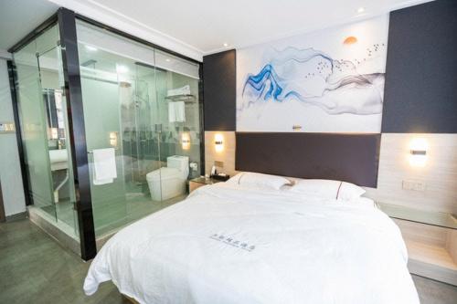 深圳深圳市华联精品酒店的卧室配有一张白色大床和玻璃淋浴间