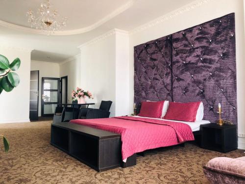 敖德萨ArkPalmira的一间卧室配有一张带粉色毯子的大床