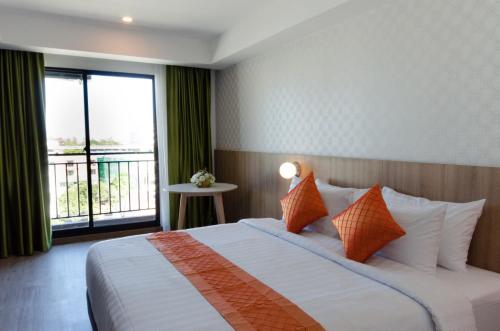 曼谷Marsi Hotel @ Bangchak的酒店客房设有一张床和一个大窗户