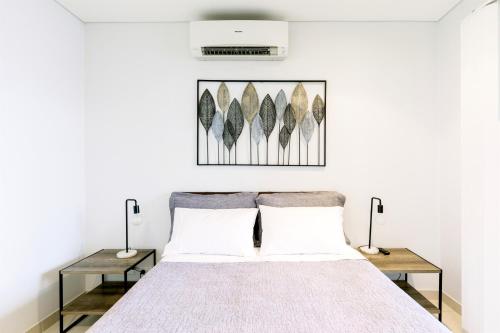 达尔文达尔文市时尚@库布公寓的一间卧室配有一张床和两张桌子