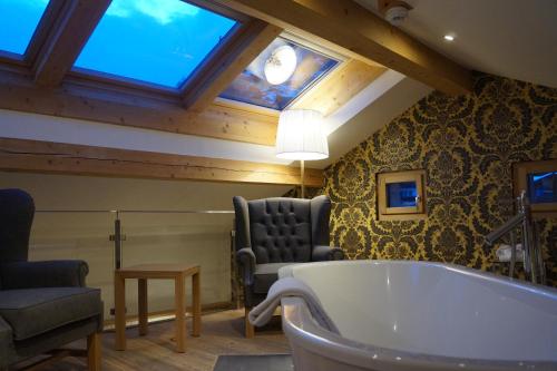 采尔马特Hotel Walliserhof Zermatt的带浴缸、椅子和沙发的浴室