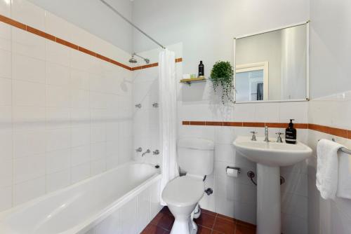 苏塞克斯入口Calm Waters Waterfront Cottages的浴室配有卫生间、盥洗盆和浴缸。