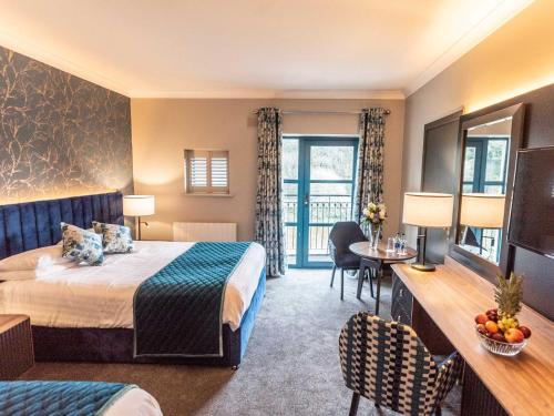 恩尼斯科西河滨公园酒店 的酒店客房带一张床、一张桌子和椅子