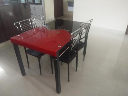 维沙卡帕特南Feel like home -Guest House near Tenneti park的一张红色桌子,四周摆放着四把椅子
