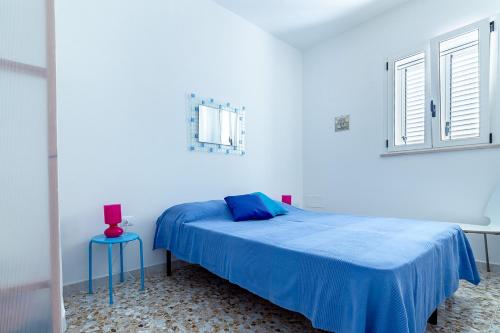 加利亚诺德尔卡波La Frisella SalentoSealovers的一间卧室设有蓝色的床和窗户。