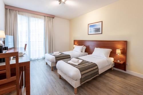 格勒诺布尔渣油格雷内特酒店的酒店客房配有两张床和一张书桌