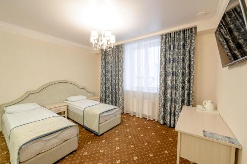 苏尔古特Hotel Aquamarin的酒店客房设有两张床和窗户。