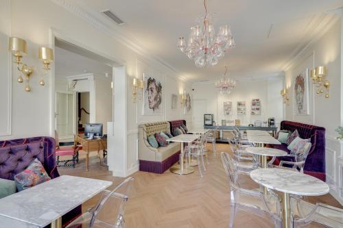 波尔多Hotel Bleu de Mer的客厅配有桌椅和吊灯。