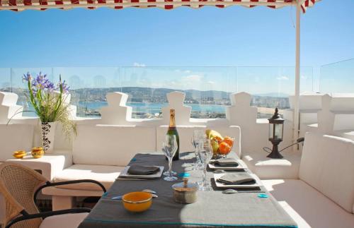 丹吉尔达累斯萨拉姆谭加酒店的阳台上的桌子和一瓶葡萄酒