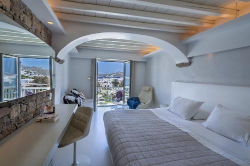 米克诺斯城Semeli Hotel Mykonos的一间卧室设有一张大床和一个大窗户
