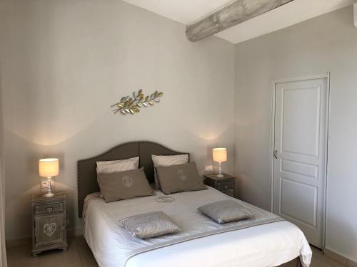 奥朗日La Chapelle的一间卧室配有一张带2个床头柜和2盏灯的床。