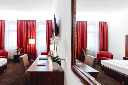 维也纳维也纳俄兰格娆酒店的酒店客房设有一张桌子和一面镜子