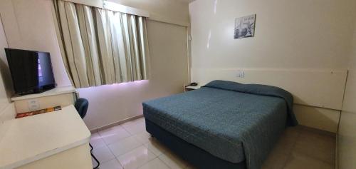 隆德里纳比利亚尔瓦酒店的小房间设有床和电视