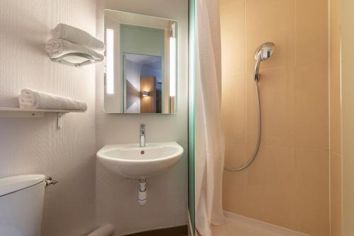 瓦朗斯B&B HOTEL Valence Sud的浴室配有盥洗盆和带镜子的淋浴