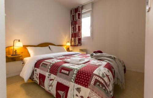 圣拉里苏朗奥德丽索莱尔多公寓式酒店的一间卧室配有一张带红白毯子的床