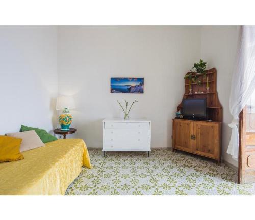 波西塔诺Casa Marty的一间卧室配有一张床、一个梳妆台和电视。