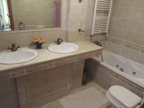 波尔图Vivenda Marinho Wix的一间带两个盥洗盆、浴缸和卫生间的浴室