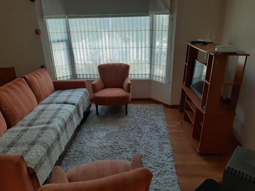 巴拉斯港Quimantu的客厅配有沙发、电视和椅子
