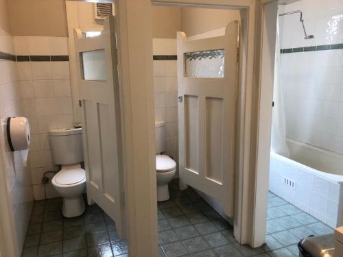 悉尼Wentworth Hotel的浴室设有2个卫生间、水槽和浴缸。